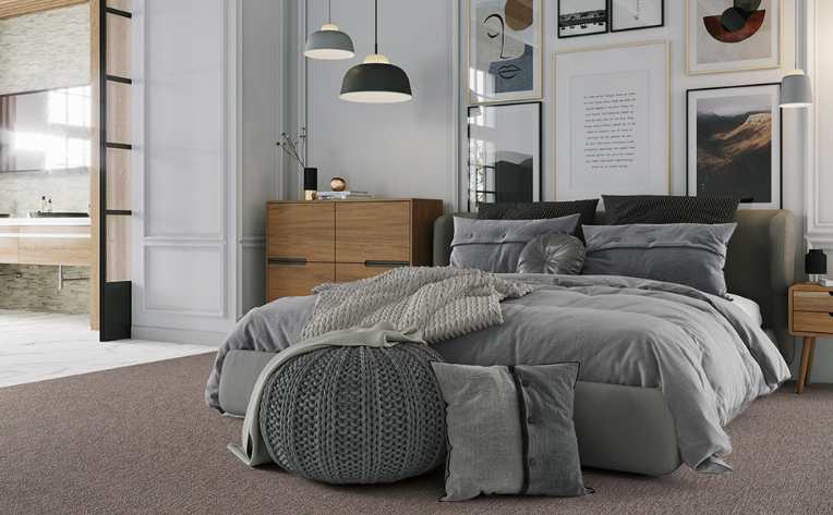 plush gray carpet in cozy layered bedroom with pendant lighting and access to master bathroom