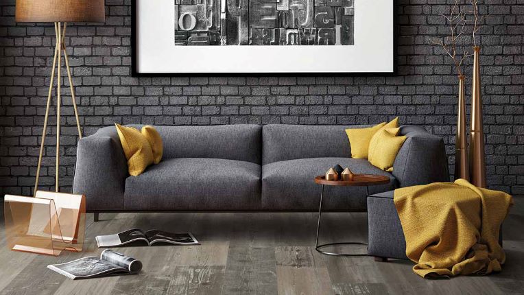 wide planked wood look luxury vinyl flooring in a modern monochrome living room with yellow accents